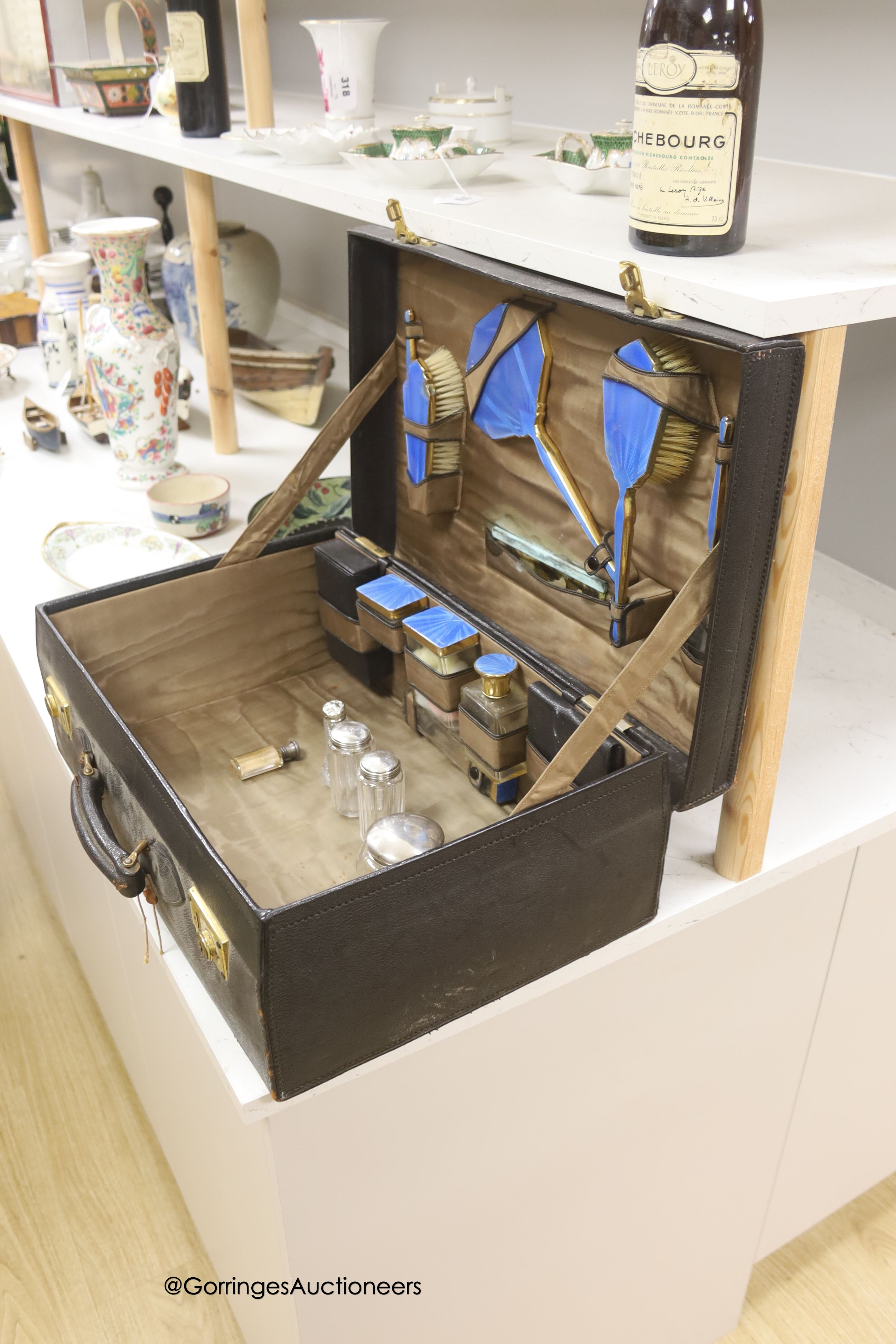 An early 20th century leather vanity case, with enclosed accessories and five further silver mounted vanity bottles